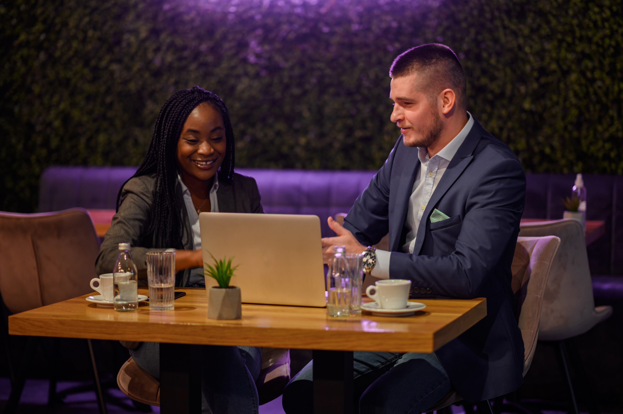 Two business people having a meeting in a cafe while using a laptop 2 Business people meeting in a cafe